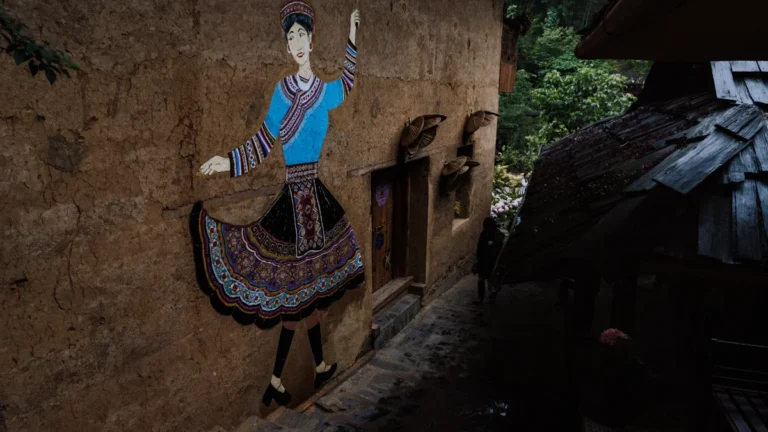A mural of a traditional folk dancer on a building wall, representing the cultural celebration of the upcoming folk festival.