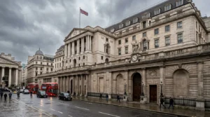 The Bank of England building on a cloudy day with red double-decker buses and black taxis.