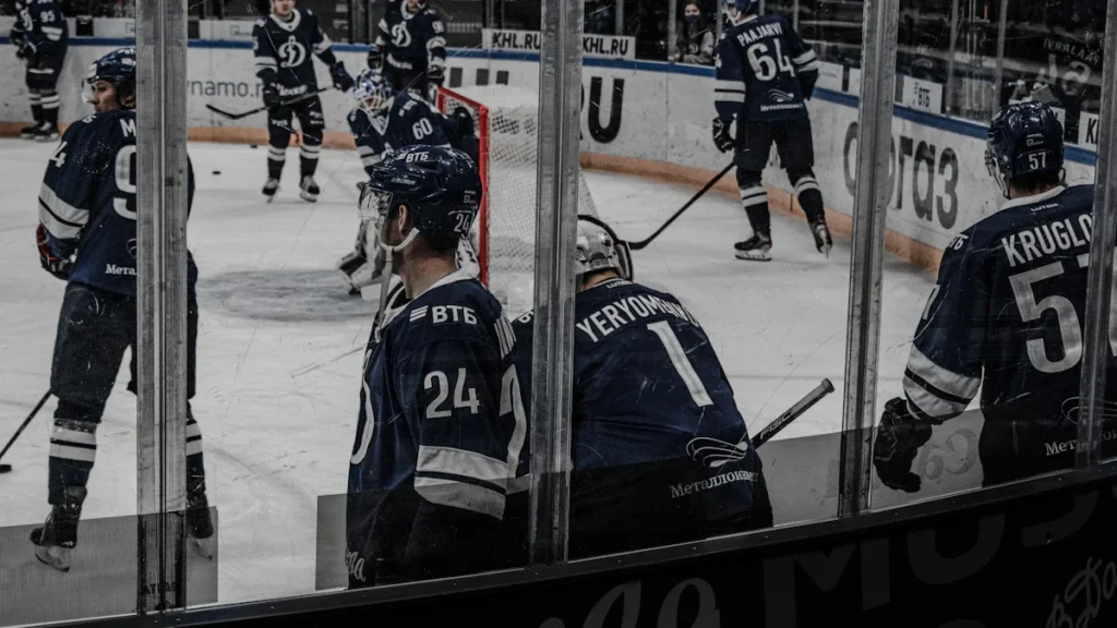 Professional ice hockey players in blue uniforms during a warm-up session on the ice rink.