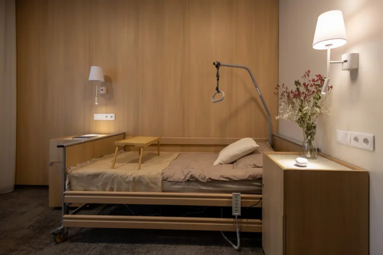 Adjustable wooden nursing bed in a cozy room with wood paneling and warm wall lighting.