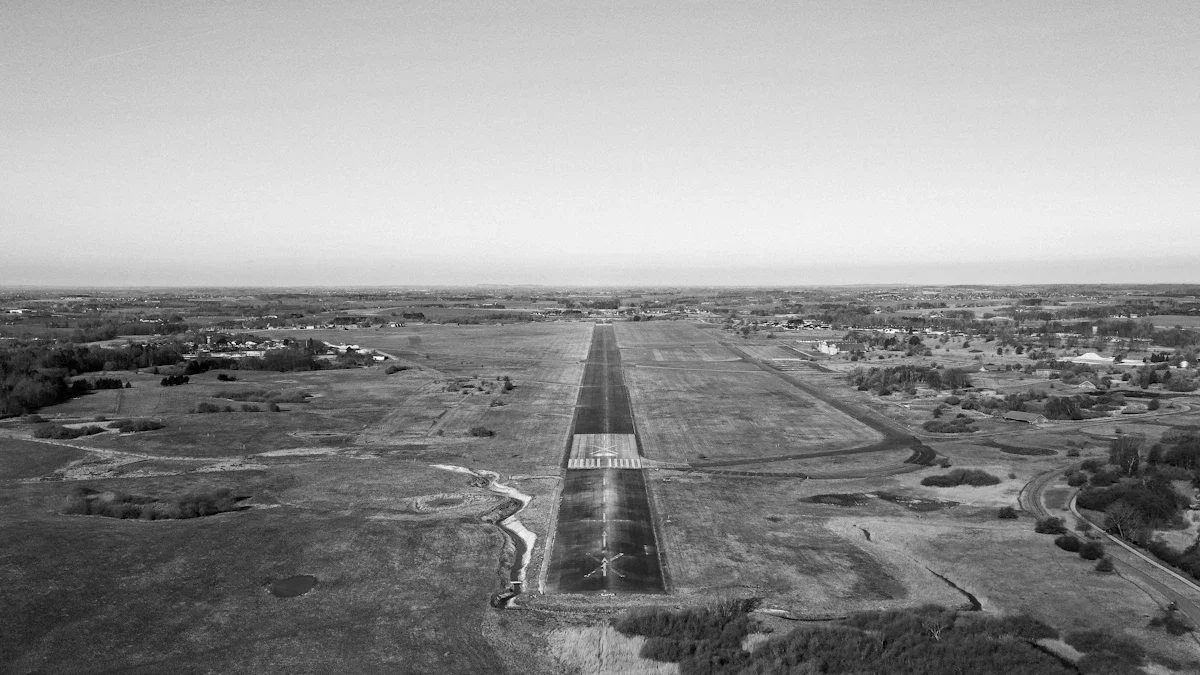 Aerial view of an expansive airfield runway in a flat, rural landscape, representing military infrastructure growth in Western Lithuania.
