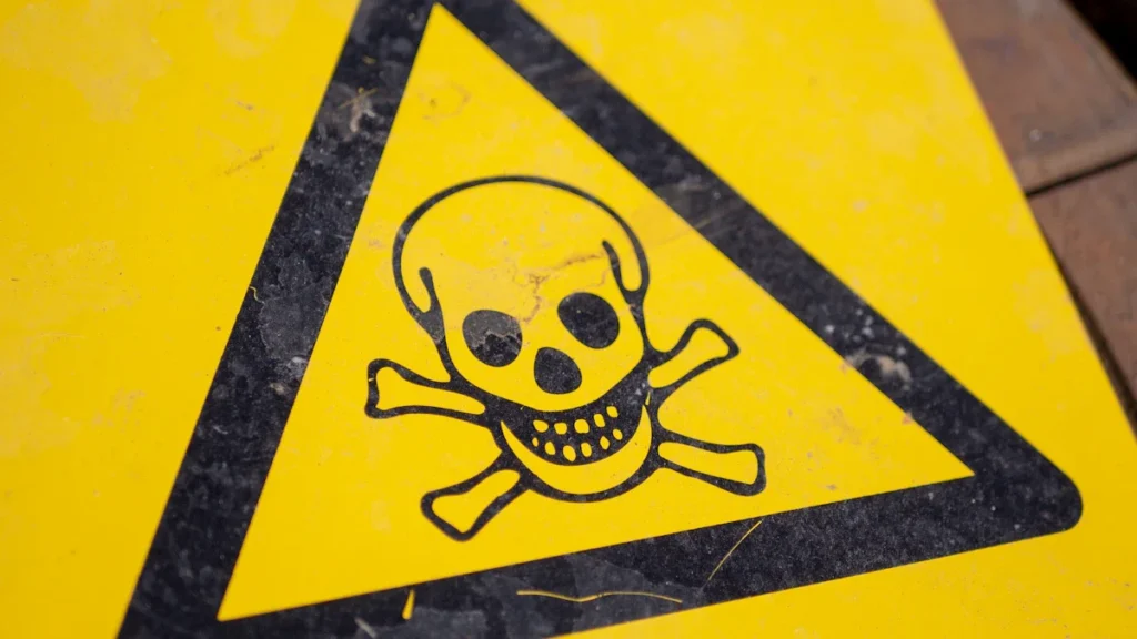 A yellow triangular warning sign featuring a black skull and crossbones symbol representing danger.