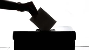 A silhouette of a hand casting a ballot into a voting box, representing the upcoming local elections in Harrow.
