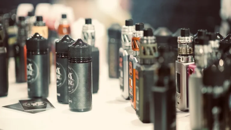 A large variety of electronic cigarette kits and e-liquid bottles displayed on a white shop counter.