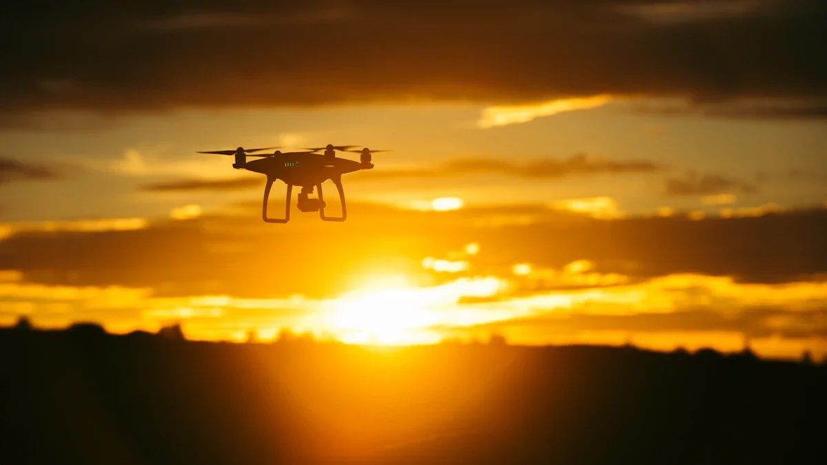 A silhouette of a quadcopter drone flying against a bright orange and yellow sunrise sky.