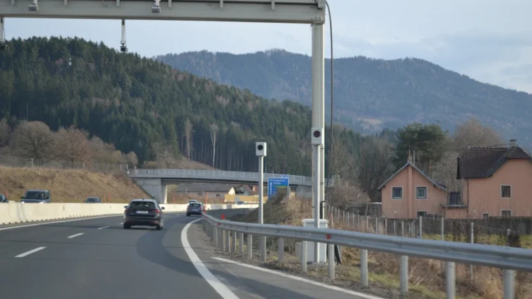 An overhead highway gantry equipped with automatic monitoring cameras and sensors.