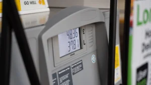 Close-up of a fuel pump nozzle and digital display showing price and volume.