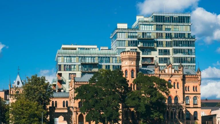 A view of historic brick buildings contrasted with modern glass residential towers in Vilnius, Lithuania.