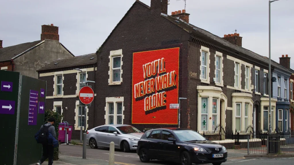Residential street in Liverpool featuring a prominent You'll Never Walk Alone mural.