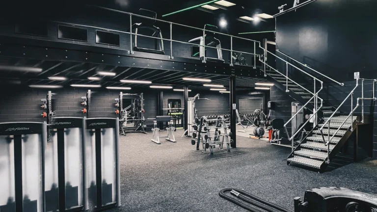 A large, modern two-story gym interior in the UK with various weight machines and equipment.