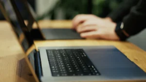 A close-up view of someone working on a laptop, representing the development and launch of a strategic five-year policy plan.