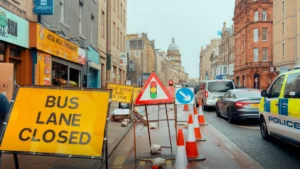 A UK police vehicle parked on a city street next to cones and 'Bus Lane Closed' signs.