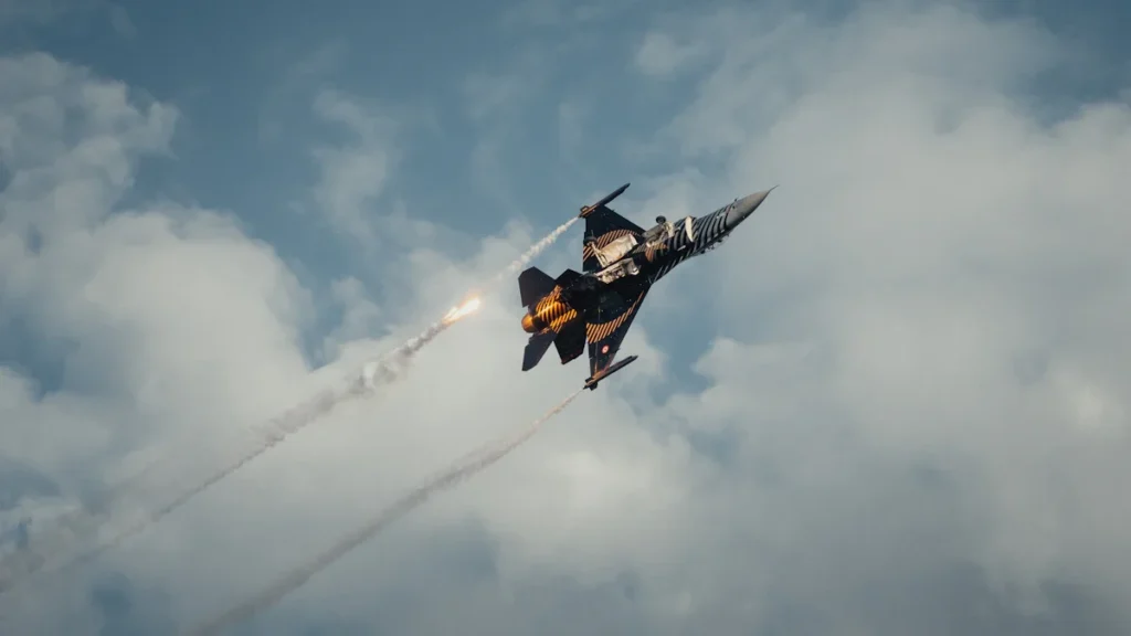 A fighter jet performing a sharp banking maneuver against a cloudy sky with visible exhaust trails.