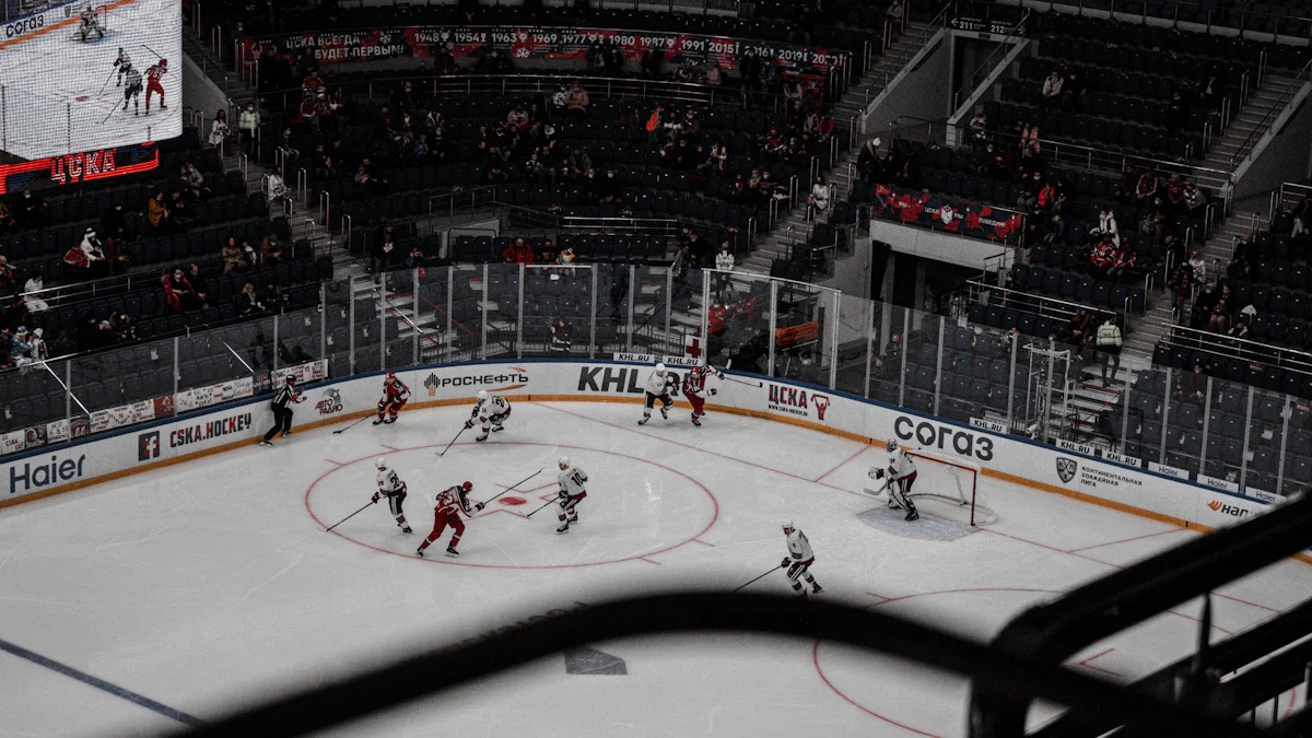 A wide-angle view of a hockey arena during a match, featuring a large screen and the ice rink.