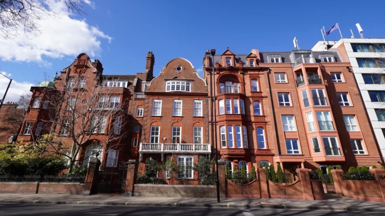 Elegant red brick residential buildings with historic architectural details on a quiet city street in the UK.