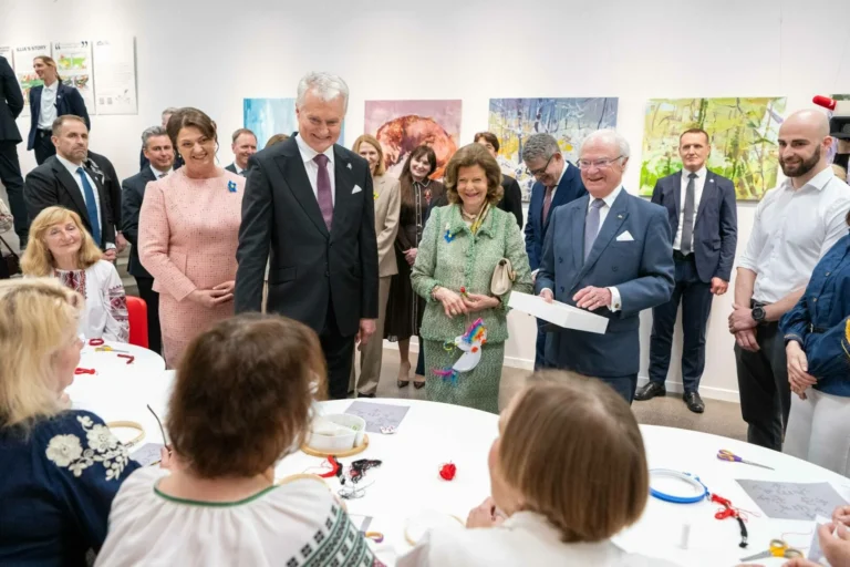 President Nausėda and Swedish royals observe people working at a craft table in a gallery.