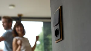 Modern black light switch and power outlet with wooden trim mounted on a gray wall.
