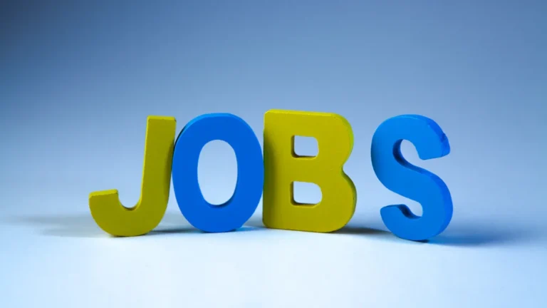 Colorful blue and yellow wooden block letters spelling the word JOBS on a plain background.