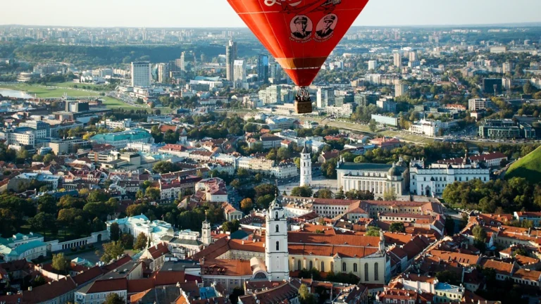 Aerial view of Vilnius old town featuring a red hot air balloon and the Palace of the Grand Dukes.