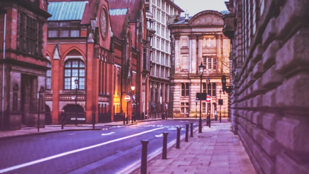 A street view of historic red brick and stone buildings on Margaret Street in central Birmingham.