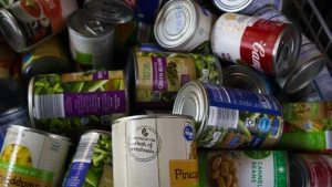 A close-up pile of assorted canned food items for charitable donation support.