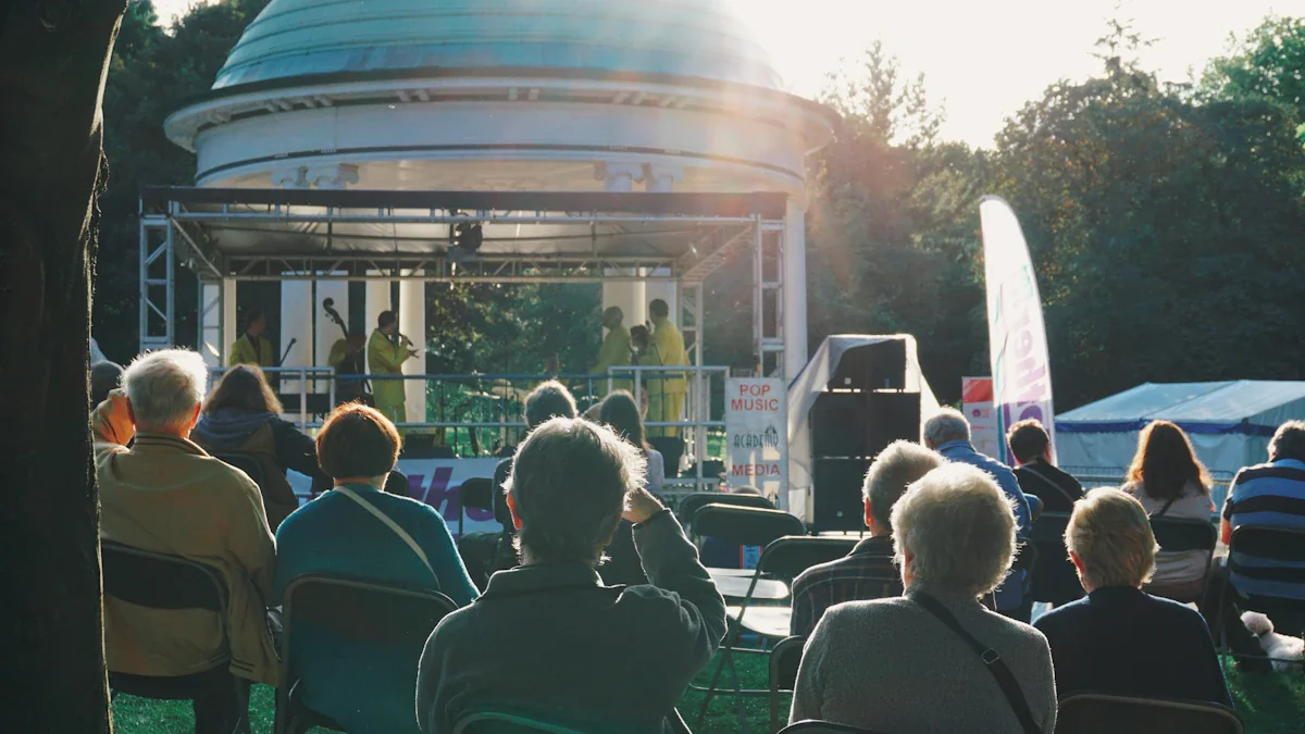 Audience watching a live band performance in a sunny public park bandstand