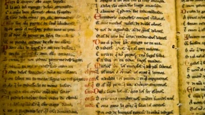 Close up view of ancient parchment manuscript with handwritten medieval text.