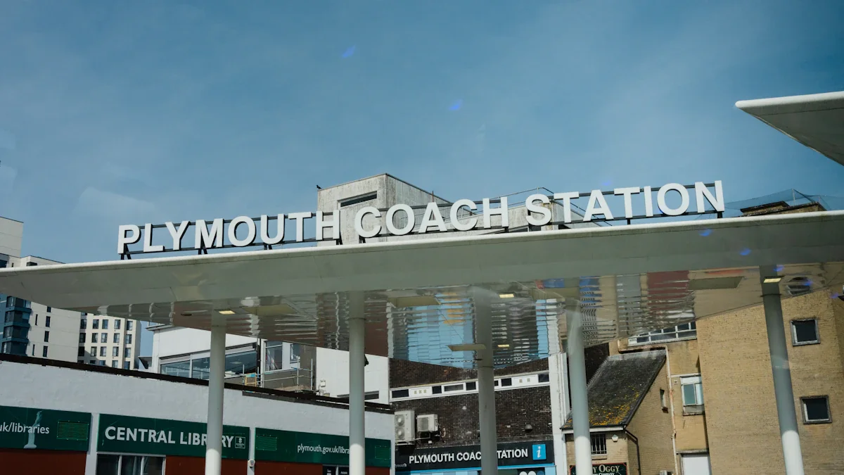 The exterior sign of Plymouth Coach Station under a clear blue sky.