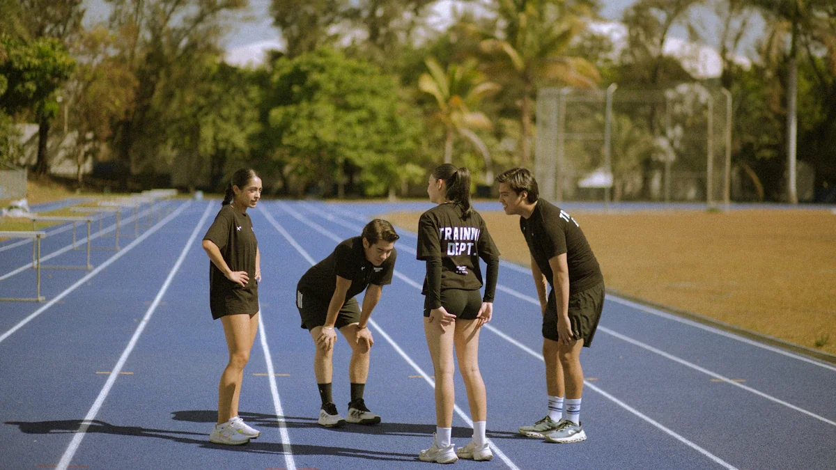 Four young athletes standing and resting together on a bright blue running track.