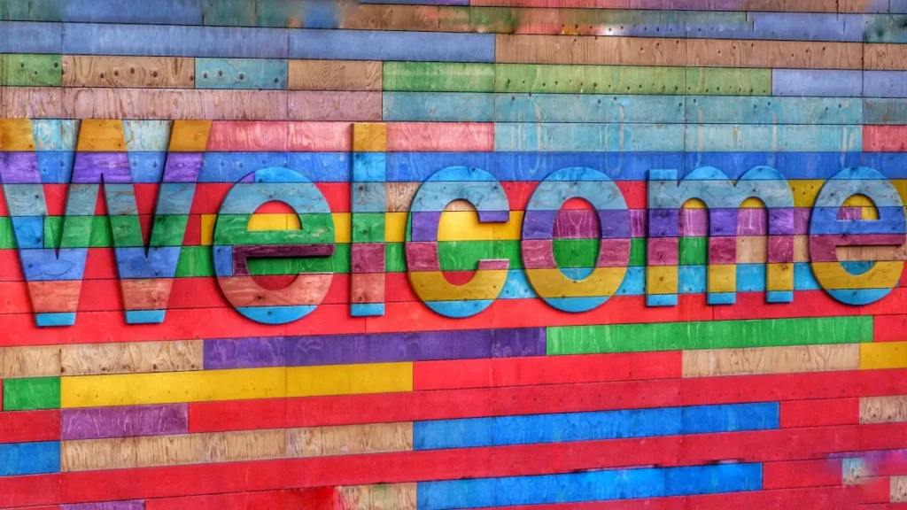 A vibrant, multi-coloured wooden sign spelling out the word Welcome.