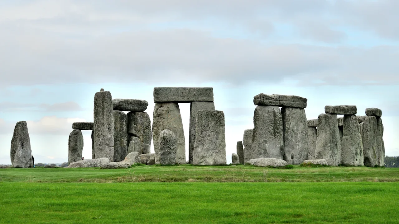 The ancient stone circle of Stonehenge standing in a lush green Wiltshire field.