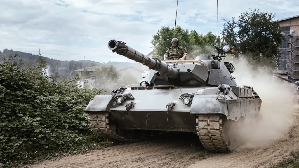 A battle tank positioned on a green grassy field during the day.