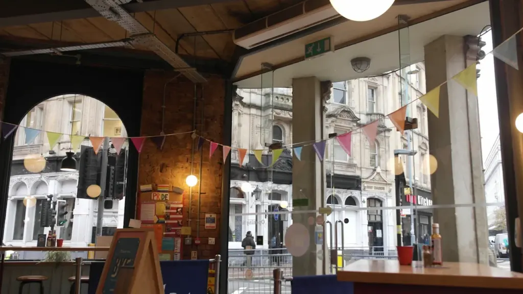 Rustic cafe interior in Birmingham city center featuring a table and street view.