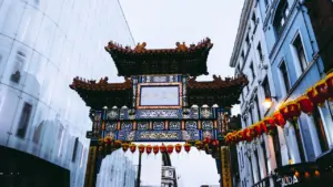 An ornate traditional archway situated in a bustling urban street environment.