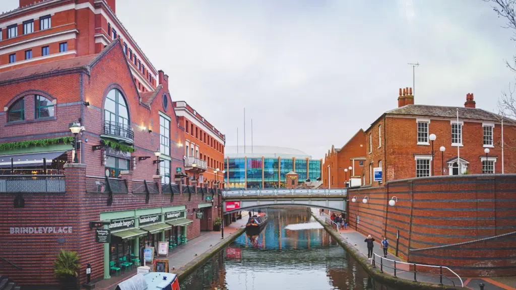 Aerial view of Birmingham city centre skyline under a dramatic cloudy sky.