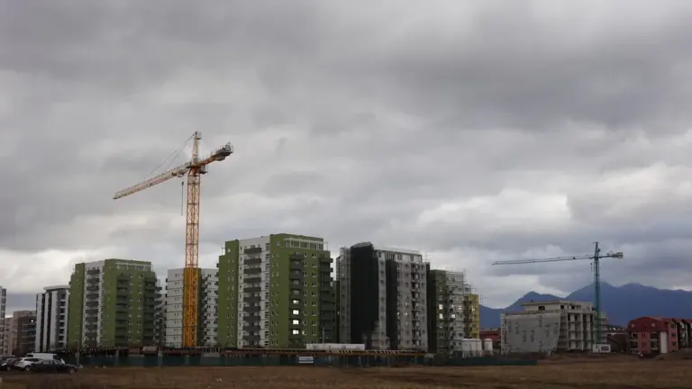 A tall construction crane standing in front of a building under development.