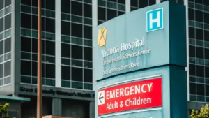 Victoria Hospital emergency department signage with hospital building in the background.