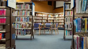 Rows of bookshelves and seating in a quiet, modern public library hub.