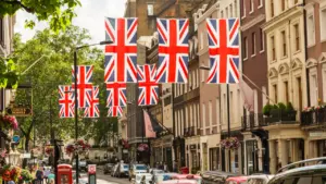 British flags hanging over a bustling city street with classic architecture