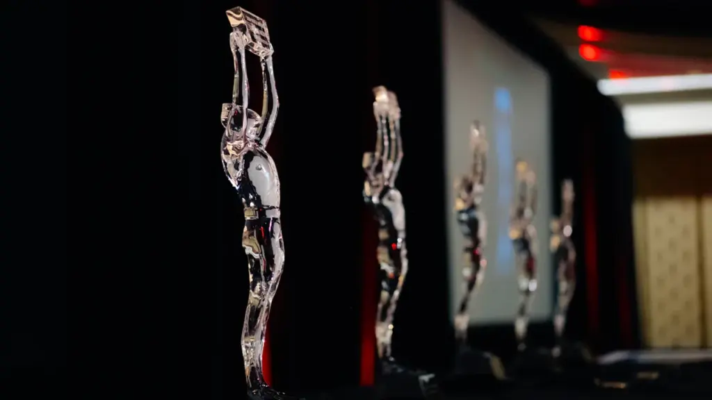 Crystal awards lined up on a stage before a business gala event.