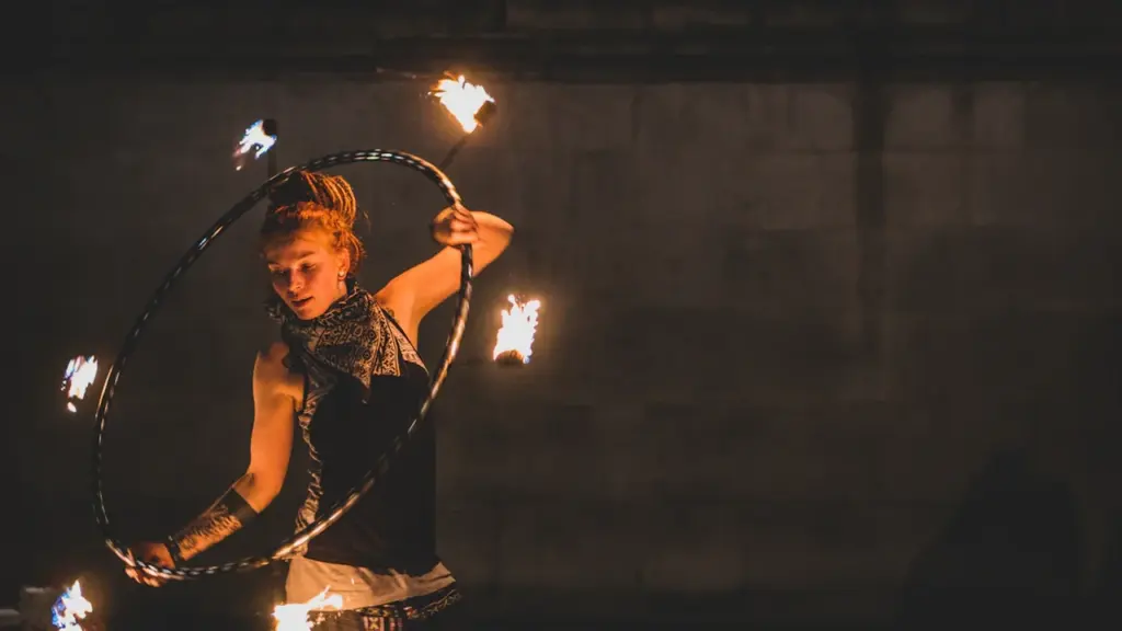 A performer using a fire-lit hula hoop during a night festival performance.