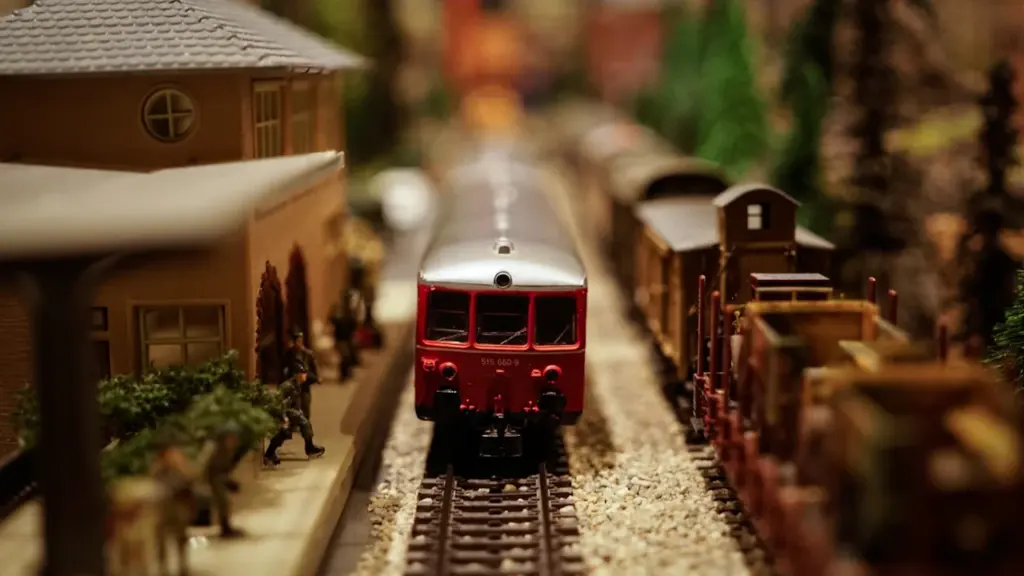 Close up of a detailed red model train at a miniature station platform
